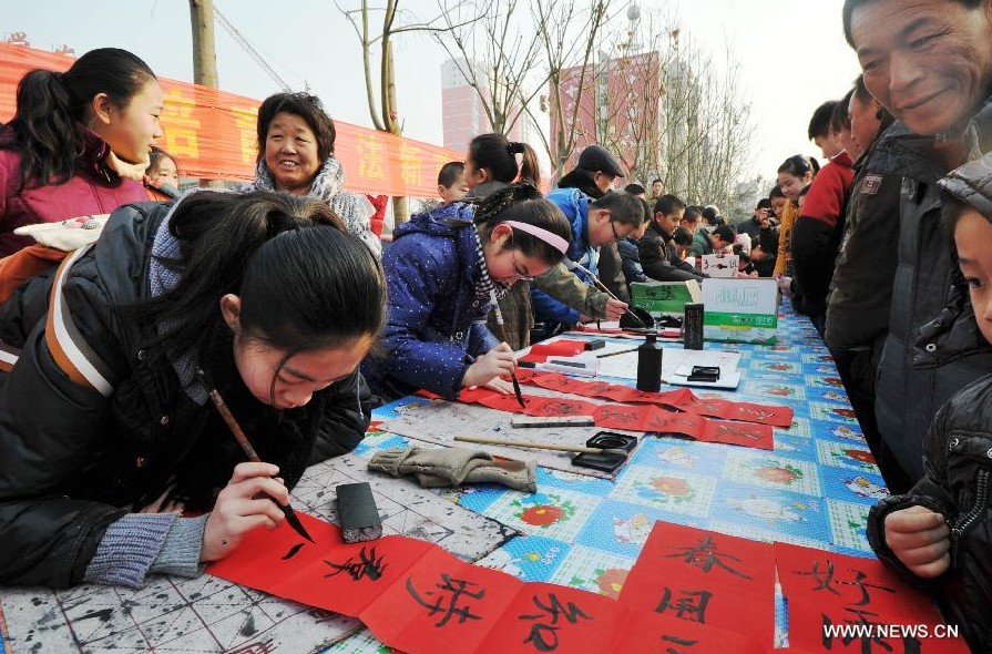 Students of calligraphy school write Spring Festival couplets for residents